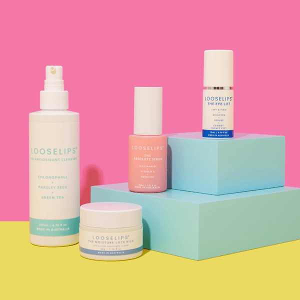 PM selfcare set consisting of the antioxidant cleanser, moisture lock rich, absolute serum and eye lift against pink and yellow background with blue props