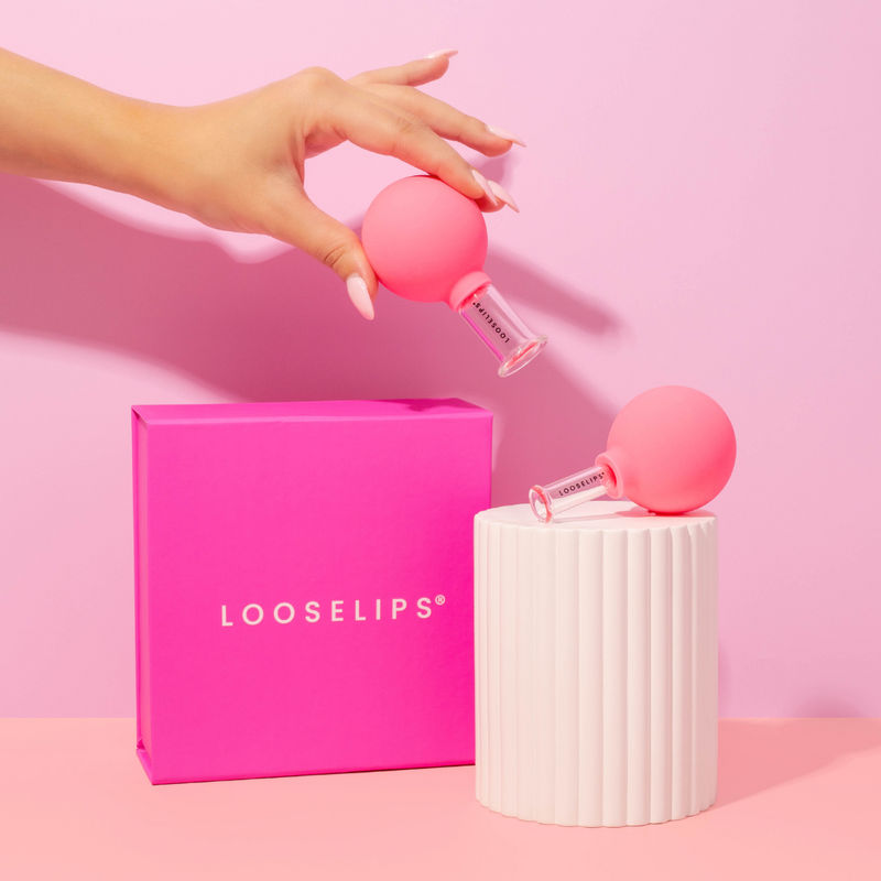 photo of a hand holding the looselips face lifters with a bright pink background and pink looselips box.